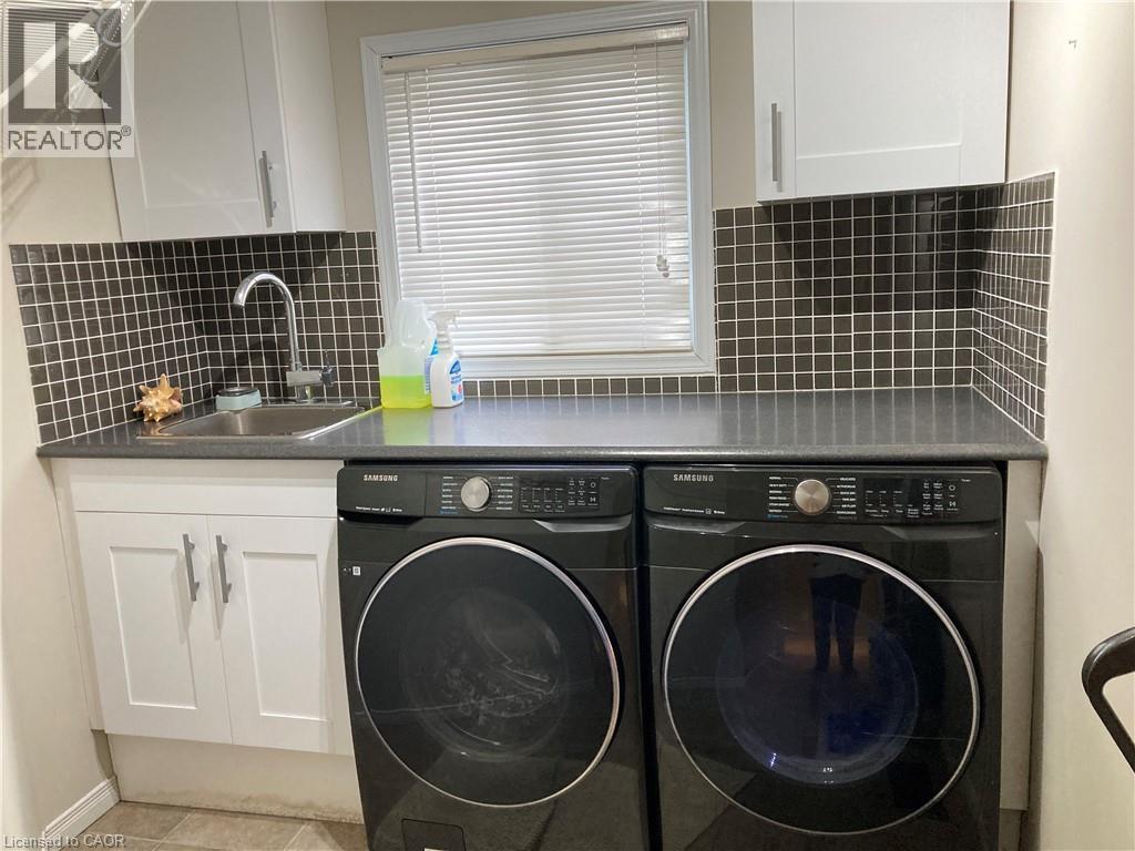 Laundry room with cabinet space, washer and clothes dryer, and tile patterned floors - 421 White Birch Avenue, Waterloo, ON - Indoor Photo Showing Laundry Room