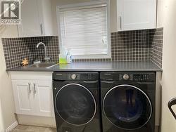 Laundry room with cabinet space, washer and clothes dryer, and tile patterned floors -