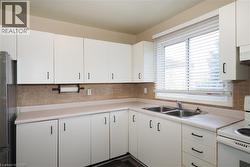 Kitchen featuring white range with electric stovetop, light countertops, and white cabinetry -