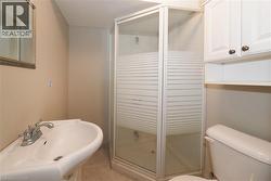 lower level Bathroom featuring a stall shower and light tile patterned floors -