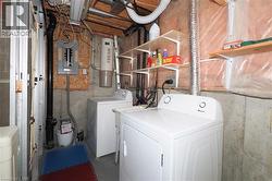 washer and dryer, electric panel, and unfinished concrete flooring -