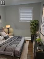 Bedroom with dark wood finished floors and baseboards -