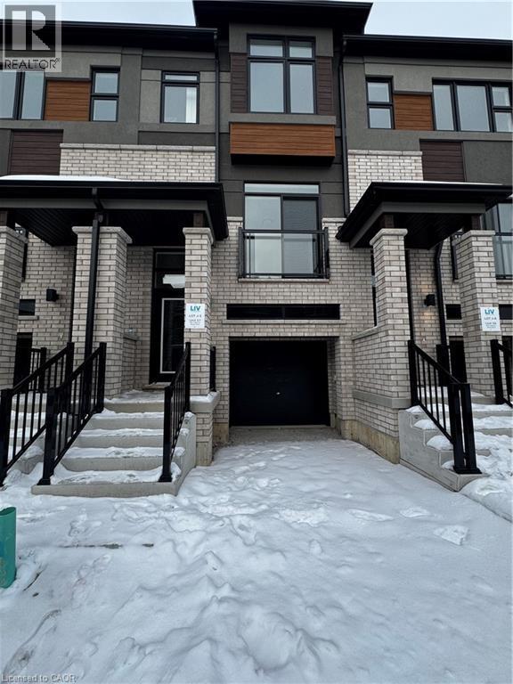 View of front of property with brick siding, stucco siding, and an attached garage - 660 Colborne Street W Unit# 57, Brantford, ON - Outdoor With Facade