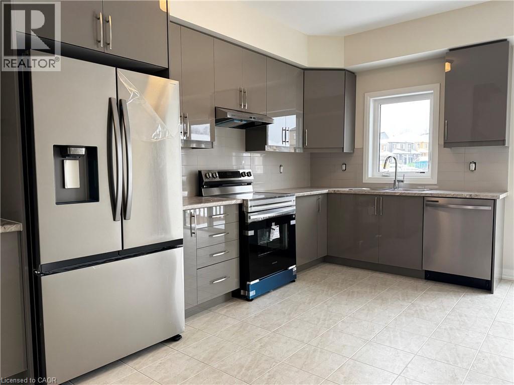 Kitchen with appliances with stainless steel finishes, under cabinet range hood, backsplash, and gray cabinets - 660 Colborne Street W Unit# 57, Brantford, ON - Indoor Photo Showing Kitchen