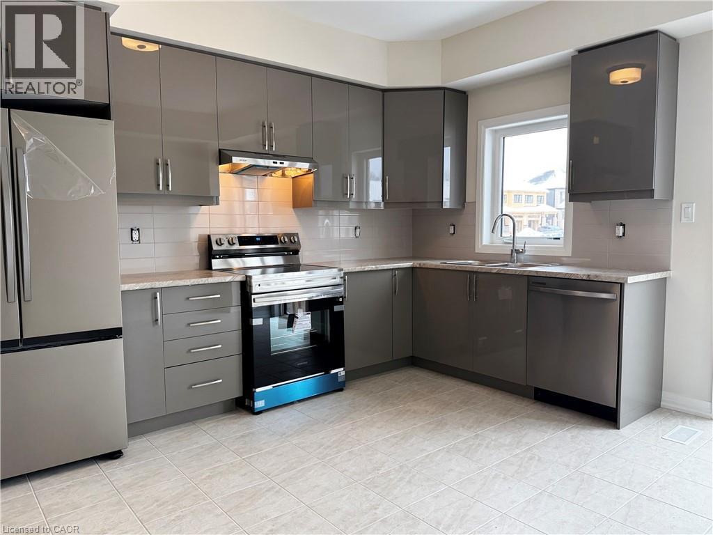 Kitchen with gray cabinetry, stainless steel appliances, decorative backsplash, and under cabinet range hood - 660 Colborne Street W Unit# 57, Brantford, ON - Indoor Photo Showing Kitchen