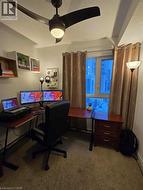 Carpeted office with a textured ceiling and ceiling fan -