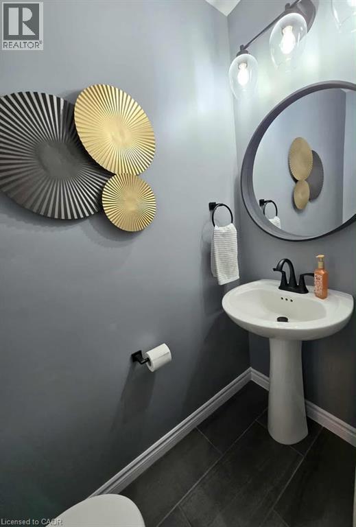 Half bathroom featuring baseboards and dark tile patterned flooring - 1430 Highland Road W Unit# 7C, Kitchener, ON - Indoor Photo Showing Bathroom