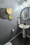 Half bathroom featuring baseboards and dark tile patterned flooring -