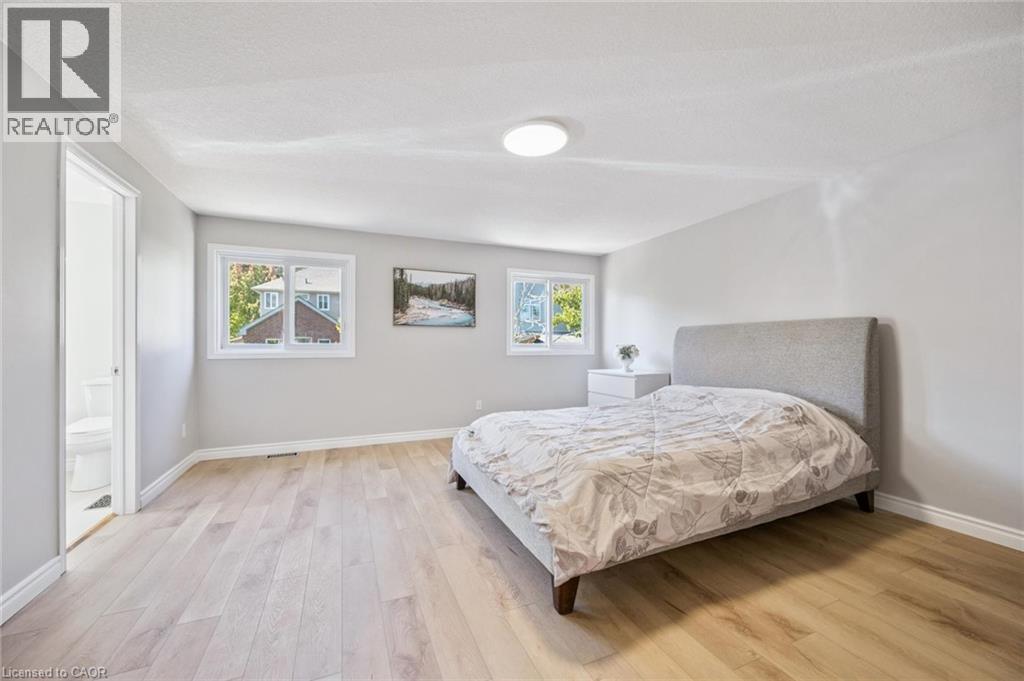 Bedroom featuring light wood-style flooring and ensuite bath - 723 Black Cherry Street, Waterloo, ON - Indoor Photo Showing Bedroom