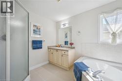 Bathroom with vanity, a bath, light tile patterned floors, and a stall shower -