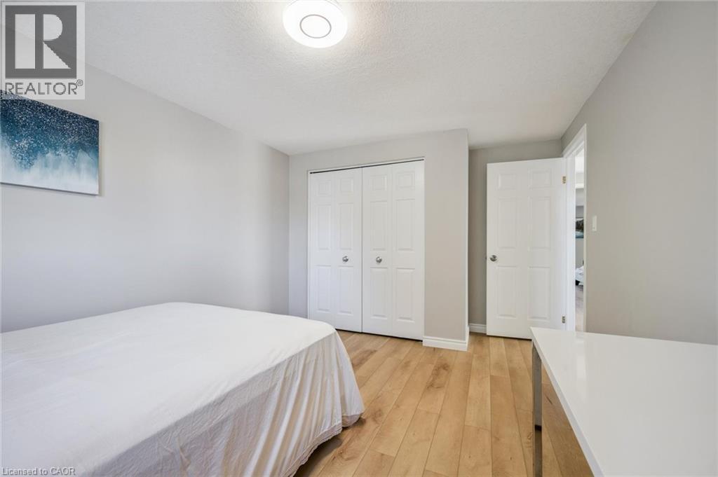 Bedroom featuring light wood-type flooring, a closet, and a textured ceiling - 723 Black Cherry Street, Waterloo, ON - Indoor Photo Showing Bedroom