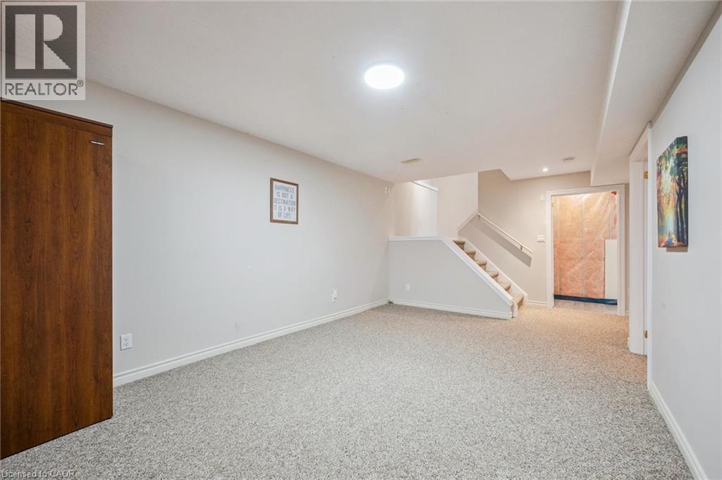 Finished basement featuring stairway and light colored carpet - 723 Black Cherry Street, Waterloo, ON - Indoor Photo Showing Other Room
