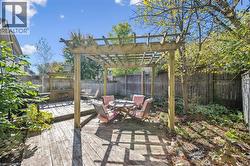 Fenced backyard with outdoor dining space, a wooden deck, and a pergola -