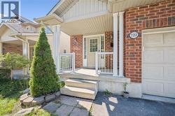 Entrance to property featuring covered porch, brick siding, and a garage -