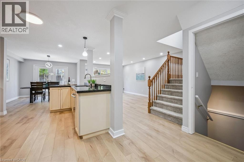 Kitchen featuring light wood-style flooring, hanging light fixtures, recessed lighting, and dark stone counters - 723 Black Cherry Street, Waterloo, ON - Indoor