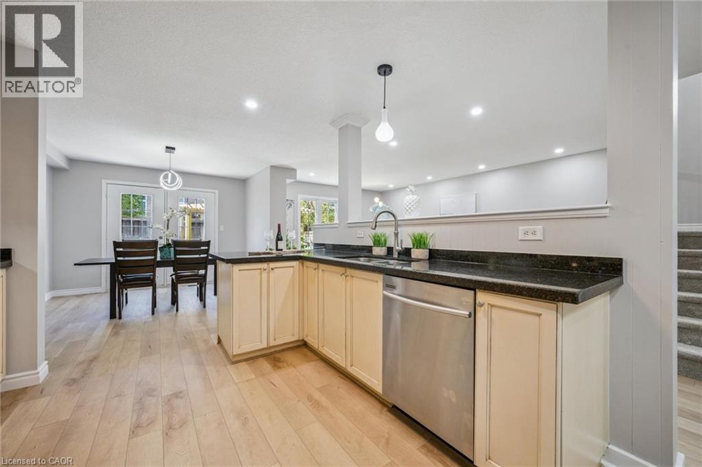 Kitchen featuring pendant lighting, dishwasher, light wood-style flooring, recessed lighting, and dark stone counters - 723 Black Cherry Street, Waterloo, ON - Indoor Photo Showing Kitchen With Upgraded Kitchen