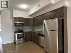 Kitchen featuring stainless steel appliances, backsplash, light wood-type flooring, and light countertops -