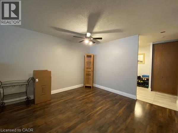 Empty room featuring a ceiling fan and dark wood finished floors - 35 Green Valley Drive Unit# 414, Kitchener, ON - Indoor Photo Showing Other Room