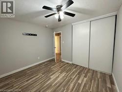 Unfurnished bedroom featuring a textured ceiling, dark wood-type flooring, a closet, and ceiling fan -