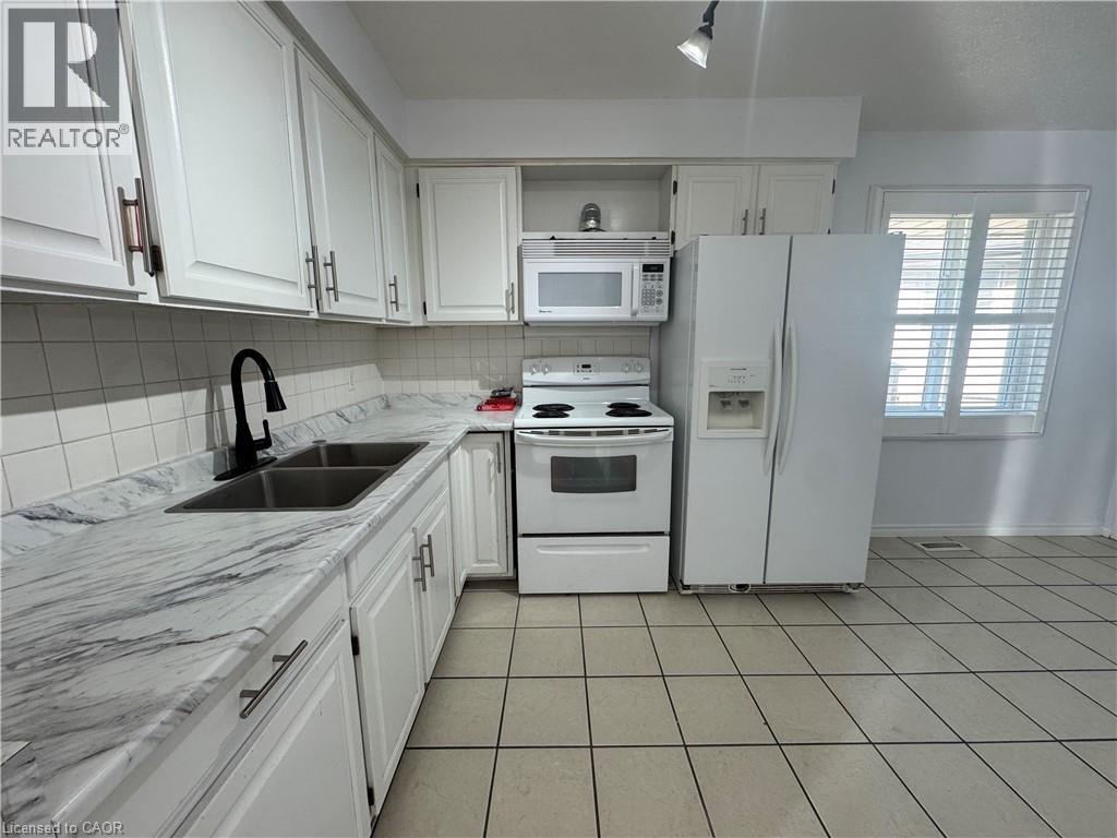 Kitchen with white appliances, white cabinetry, and open shelves - 86 Hillsborough Crescent Unit# Main, Kitchener, ON - Indoor Photo Showing Kitchen With Double Sink
