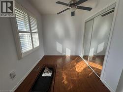 Unfurnished bedroom with dark wood-style floors, ceiling fan, and a closet -