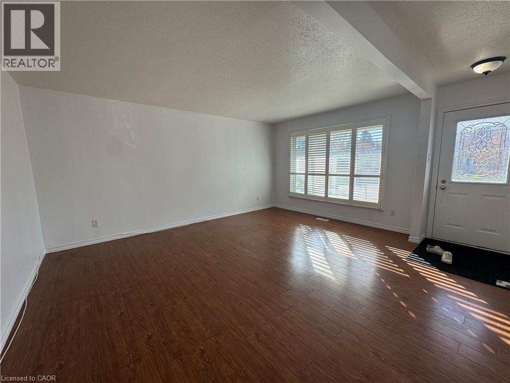Foyer entrance featuring a textured ceiling and dark wood finished floors - 86 Hillsborough Crescent Unit# Main, Kitchener, ON - Indoor Photo Showing Other Room