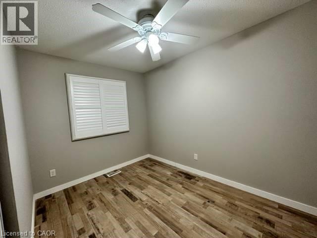 Empty room with light wood-style floors, a ceiling fan, and a textured ceiling - 86 Hillsborough Crescent Unit# Main, Kitchener, ON - Indoor Photo Showing Other Room