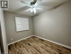 Empty room with light wood-style floors, a ceiling fan, and a textured ceiling -