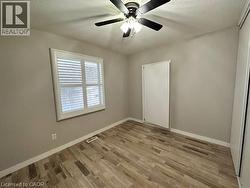 Empty room featuring a textured ceiling, light wood-type flooring, and ceiling fan -