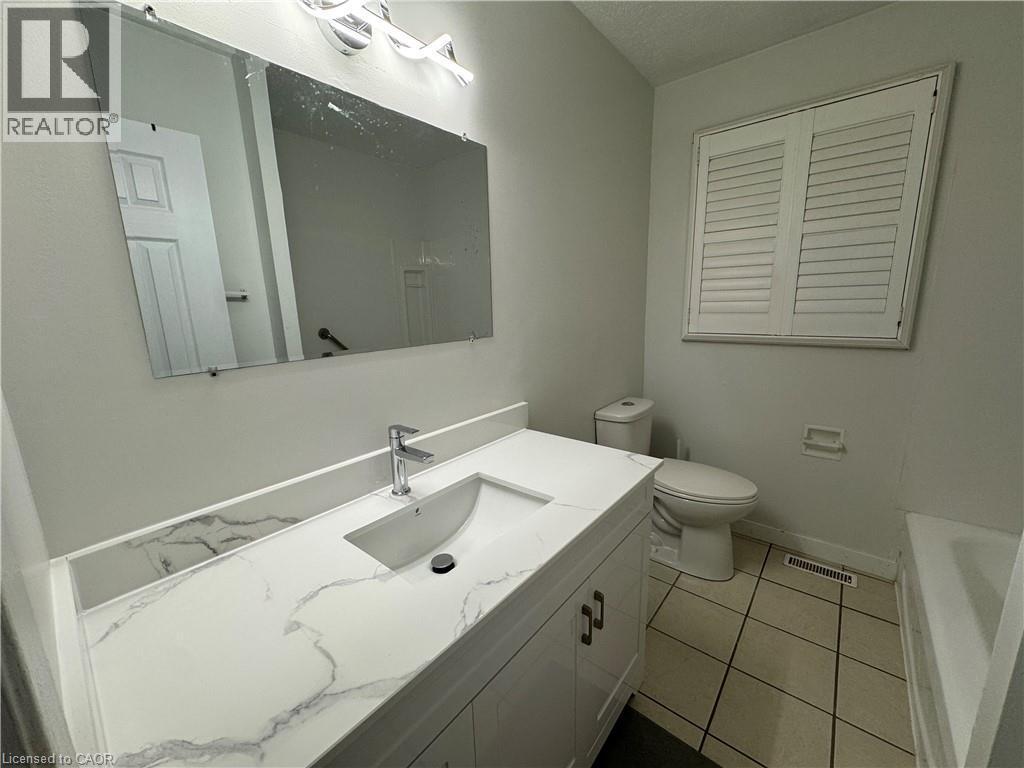 Bathroom with vanity, a tub, and light tile patterned floors - 86 Hillsborough Crescent Unit# Main, Kitchener, ON - Indoor Photo Showing Bathroom