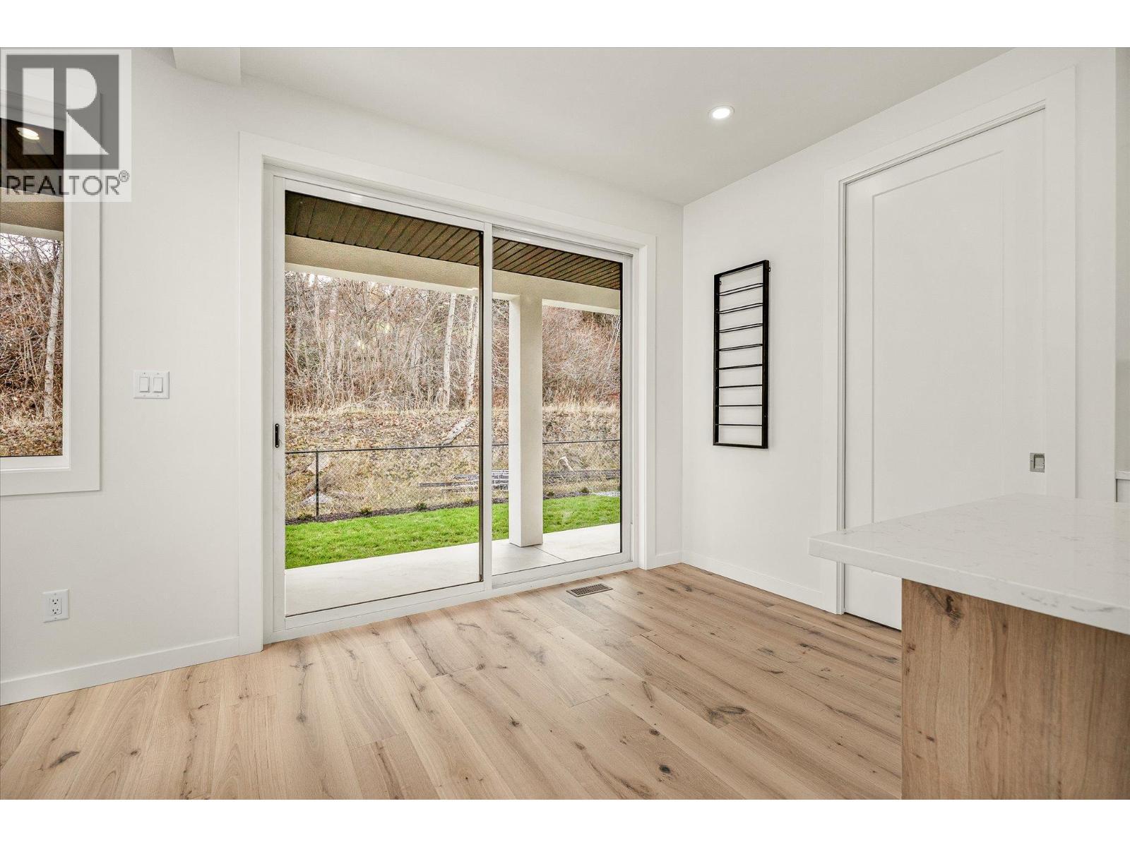 large sliders to covered patio - 980 Bull Crescent, Kelowna, BC - Indoor Photo Showing Other Room