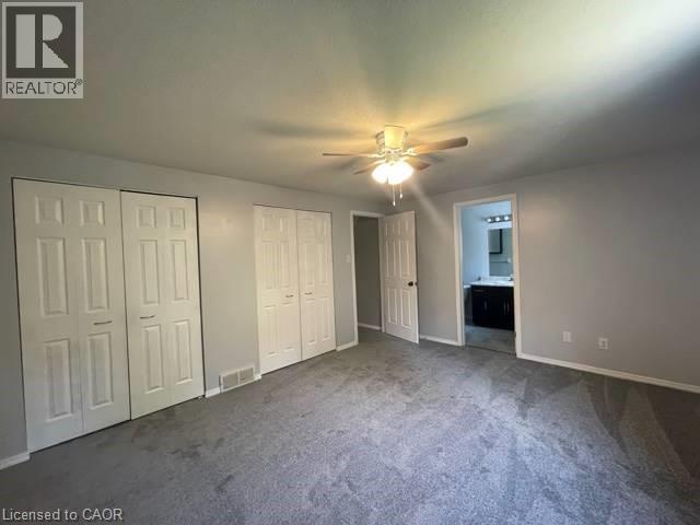 Unfurnished bedroom featuring multiple closets, carpet floors, ensuite bathroom, and a ceiling fan - 214 Benesfort Crescent, Kitchener, ON - Indoor Photo Showing Other Room