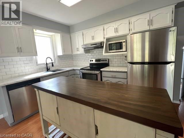 Kitchen featuring stainless steel appliances, backsplash, white cabinets, and butcher block countertops - 214 Benesfort Crescent, Kitchener, ON - Indoor Photo Showing Kitchen With Upgraded Kitchen