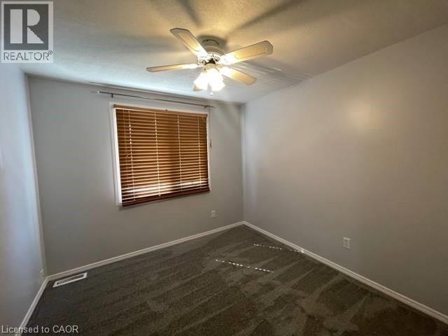 Empty room featuring dark colored carpet and ceiling fan - 214 Benesfort Crescent, Kitchener, ON - Indoor Photo Showing Other Room