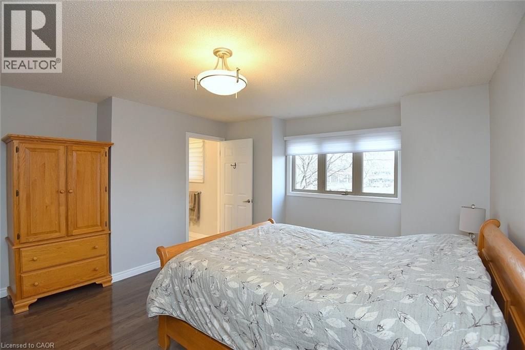 Bedroom with a textured ceiling and dark wood-style floors - 1245 Stephenson Drive Unit# 20, Burlington, ON
