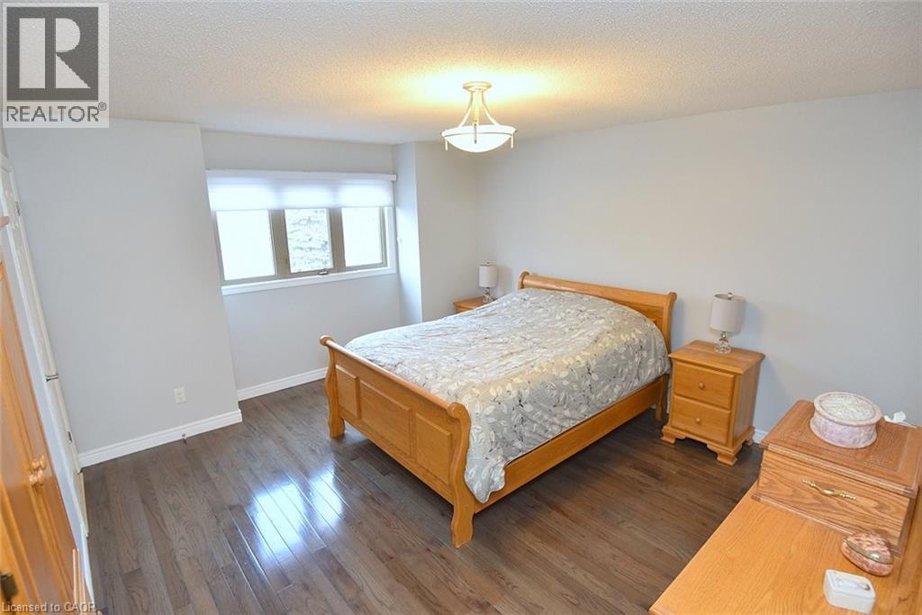 Bedroom with a textured ceiling and wood finished floors - 1245 Stephenson Drive Unit# 20, Burlington, ON