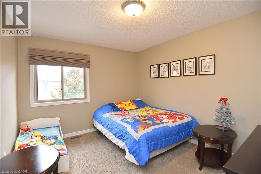 Carpeted bedroom featuring a textured ceiling and baseboards - 1245 Stephenson Drive Unit# 20, Burlington, ON