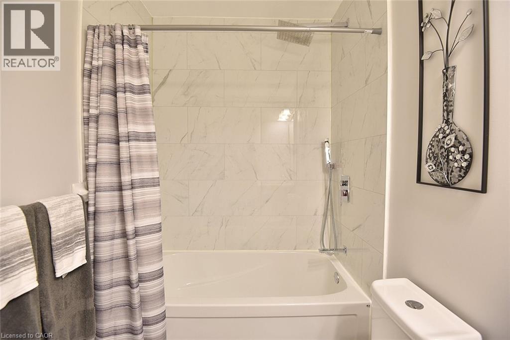 Bathroom featuring shower / bath combo and toilet - 1245 Stephenson Drive Unit# 20, Burlington, ON