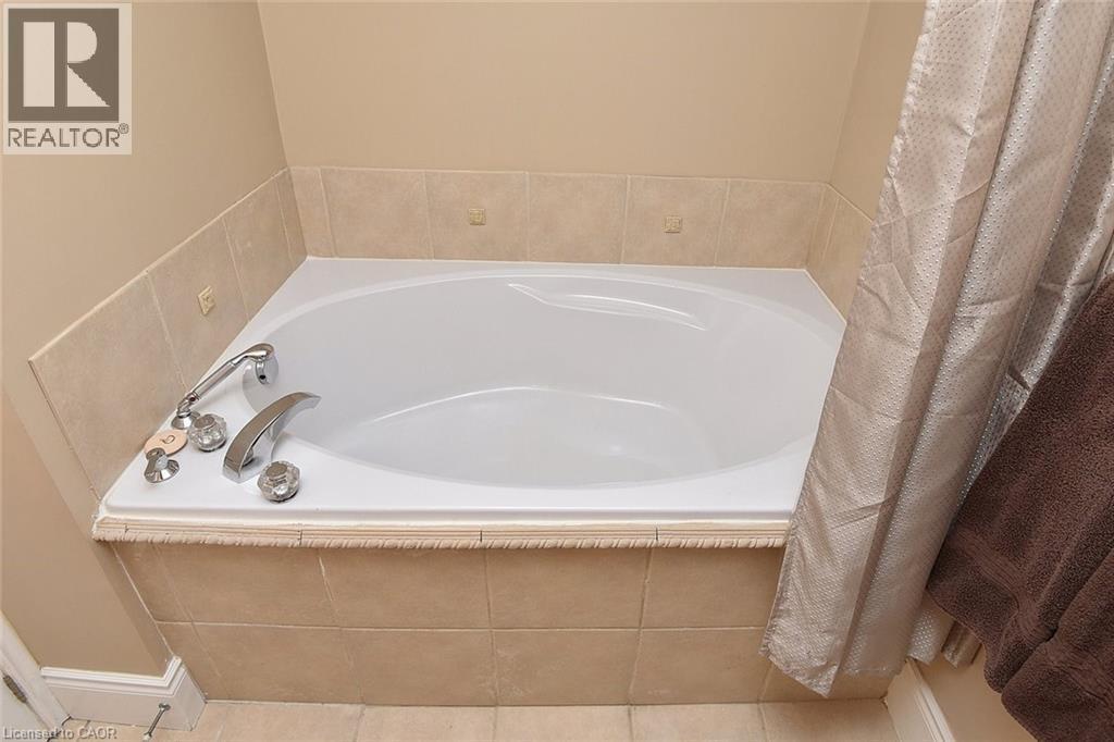 Bathroom with a bath and tile patterned floors - 1245 Stephenson Drive Unit# 20, Burlington, ON