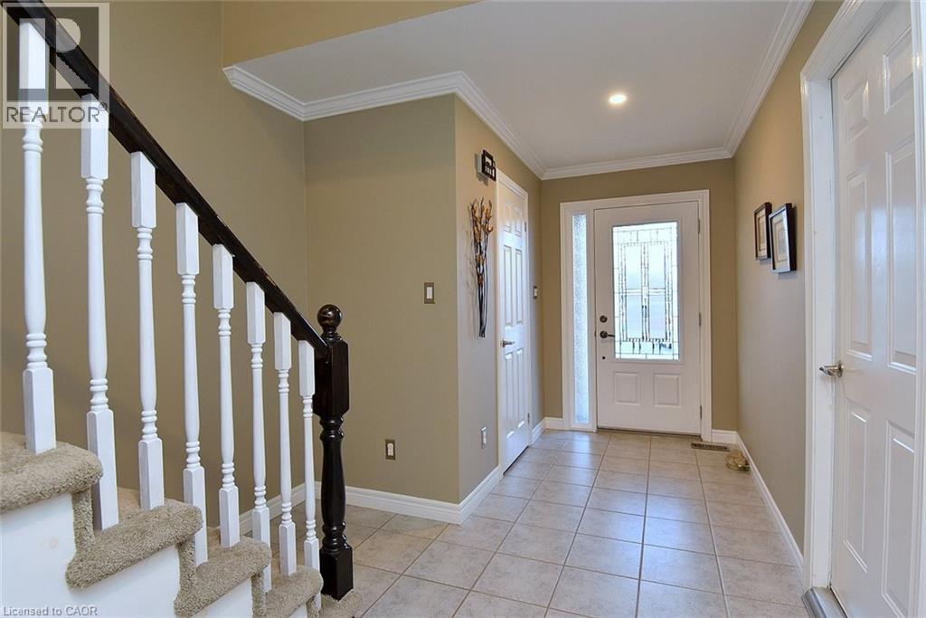 Foyer entrance featuring stairs, light tile patterned flooring, and ornamental molding - 1245 Stephenson Drive Unit# 20, Burlington, ON
