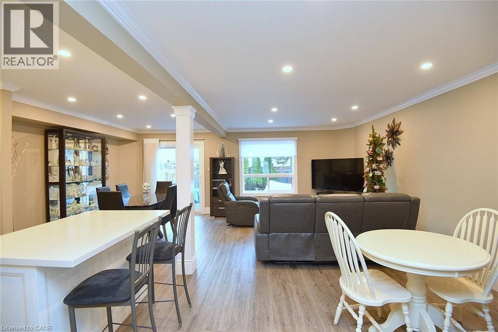 Dining room with crown molding, light wood-style flooring, recessed lighting, and decorative columns - 1245 Stephenson Drive Unit# 20, Burlington, ON