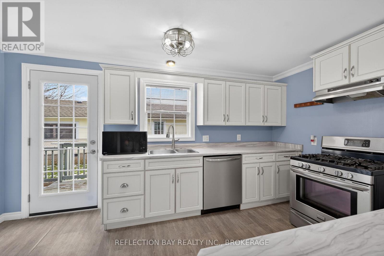 French door leading to the spacious backyard deck - 3794 Mathewson Avenue, Fort Erie (Crystal Beach), ON - Indoor Photo Showing Kitchen With Stainless Steel Kitchen With Double Sink