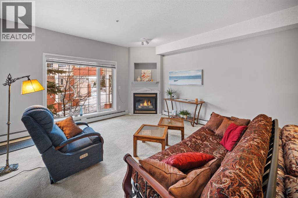 201, 223 Tuscany Springs Boulevard Nw, Calgary, AB - Indoor Photo Showing Living Room With Fireplace
