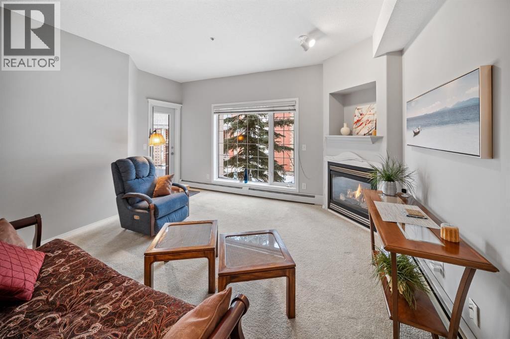 201, 223 Tuscany Springs Boulevard Nw, Calgary, AB - Indoor Photo Showing Living Room With Fireplace