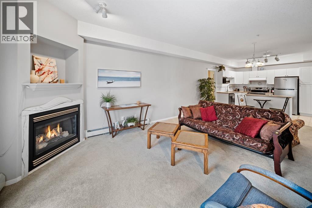 201, 223 Tuscany Springs Boulevard Nw, Calgary, AB - Indoor Photo Showing Living Room With Fireplace