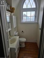 Half bath featuring vanity and dark wood finished floors -