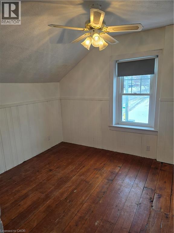 Additional living space featuring ceiling fan, vaulted ceiling, dark wood-type flooring, a wainscoted wall, and a textured ceiling - 10 Centre Street, Elmira, ON - Indoor Photo Showing Other Room