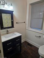 Bathroom featuring vanity and dark wood-style floors -
