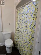 Bathroom featuring toilet and a shower with curtain -