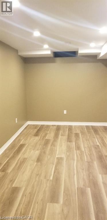 Finished below grade area with light wood-type flooring and baseboards - 185 Sulmona Drive, Hamilton, ON - Indoor